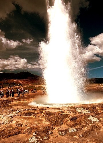 Tourists watching Strokkur Geyser in full eruption, Iceland